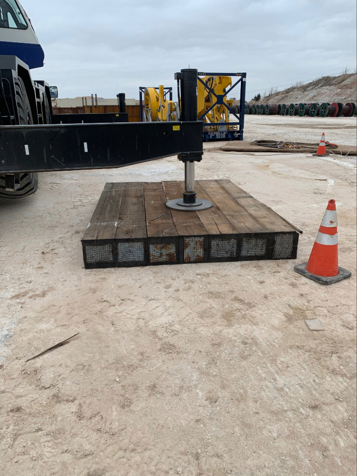 Outrigger mat distributing concentrated crane loads at transmission site